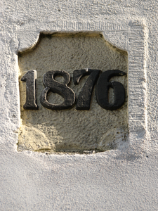 817624 Afbeelding van een sluitsteen met het jaartal 1876, gemetseld in de zijgevel van het pand Oosterkade 15 te ...